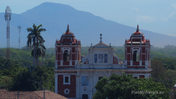 Colonial church in León with a volcano rising in the background, Nicaragua
